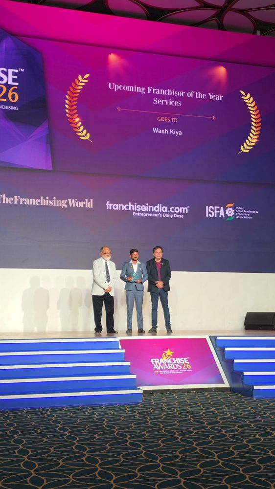 Washkiya receiving the Upcoming Franchisor of the Year – Services award on stage